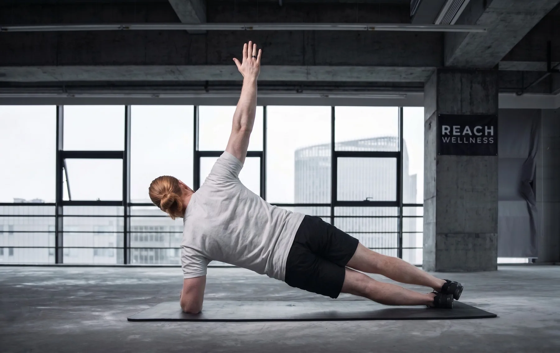 A man holding a side plank on a mat
