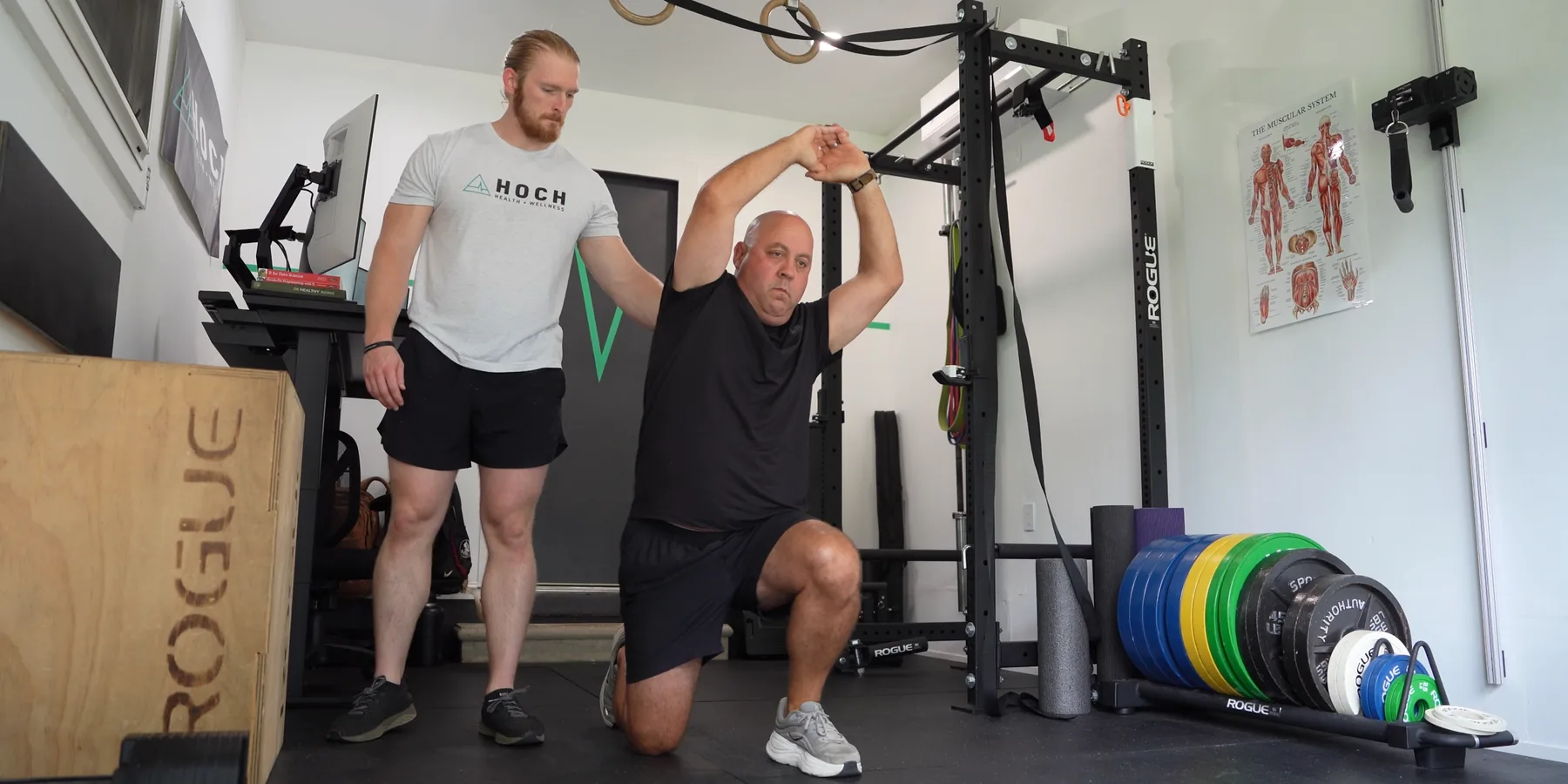 A coach guiding a client up from the floor